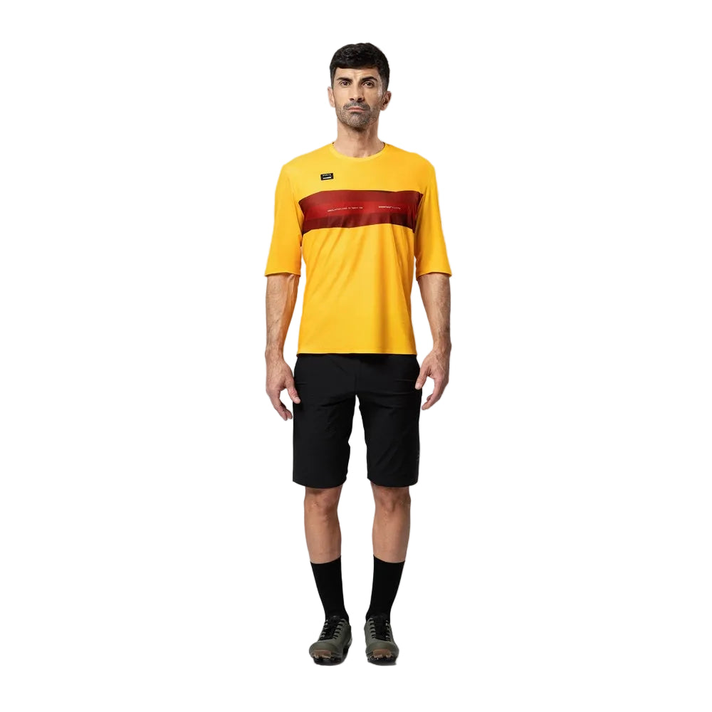 Man wearing yellow Gobik Volt cycling shirt with red stripe and black shorts