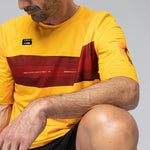 Man wearing yellow Gobik Volt t-shirt with red stripes in studio setting