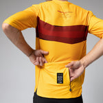 Gobik Volt cycling jersey in yellow with red stripe, model showing back view
