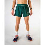 Man wearing ChicknLegs forest green athletic shorts with split hem design