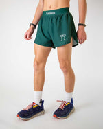 Man wearing ChicknLegs forest green athletic running shorts with split hem design