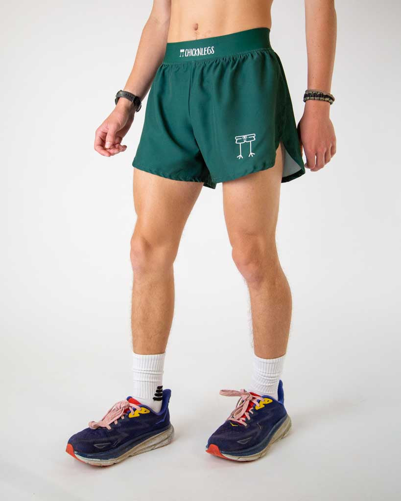 Man wearing ChicknLegs forest green athletic running shorts with split hem design