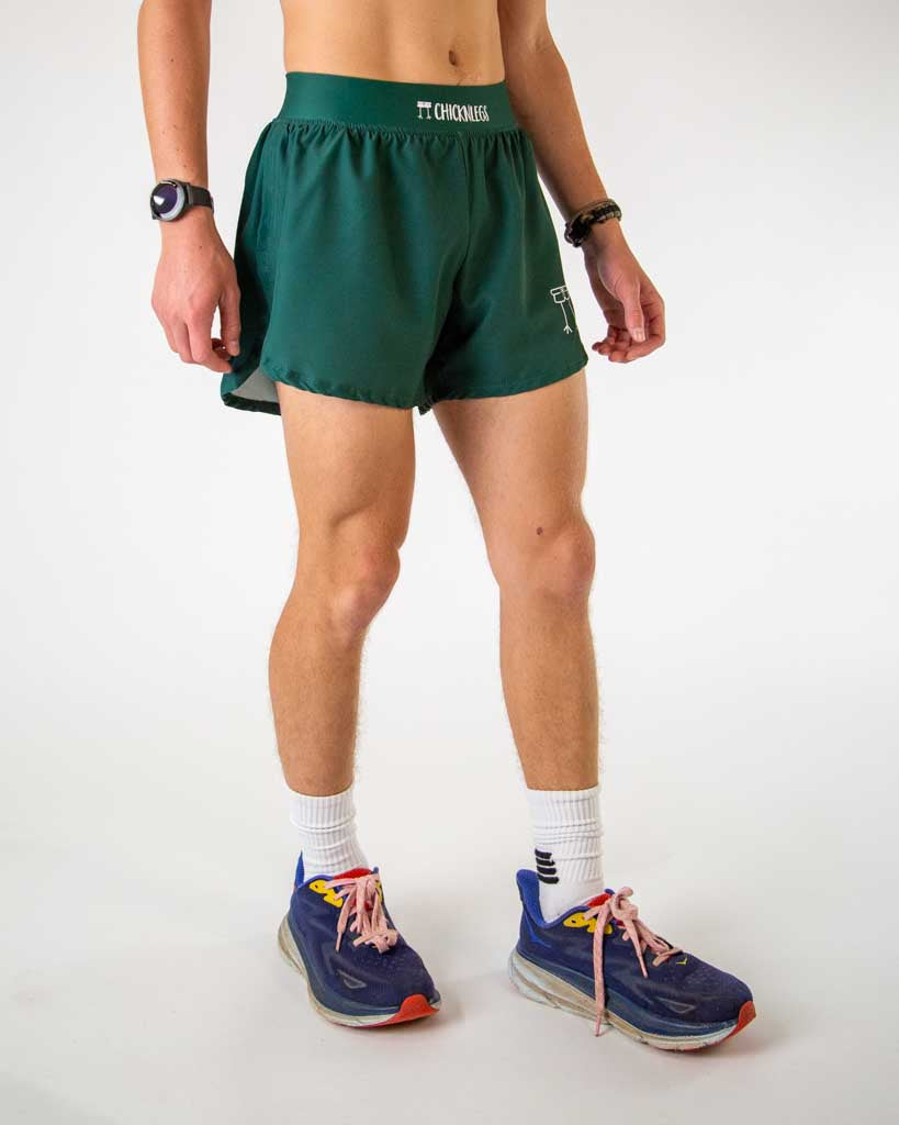 Man wearing ChicknLegs forest green running shorts with split hem design