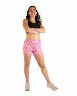 Woman wearing pink polka dot athletic shorts with black sports bra