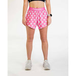 Woman wearing pink polka dot athletic shorts with ChicknLegs waistband