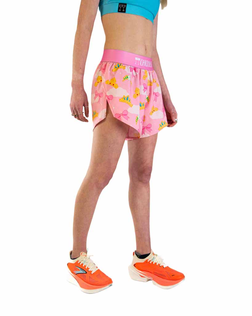 Woman wearing pink ChicknLegs split shorts with princess tiara pattern and teal sports bra