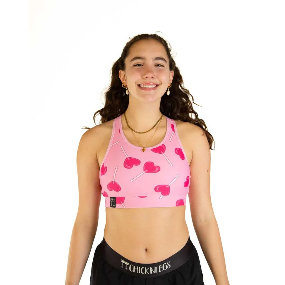 Pink sports bra with lollipop candy print pattern on smiling model