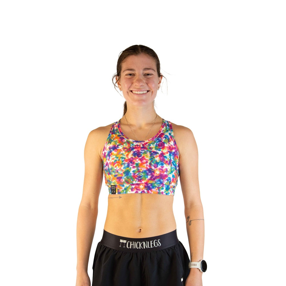 Woman wearing ChicknLegs tie-dye sports bra in vibrant multicolor pattern
