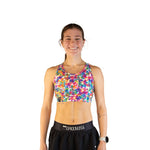 Woman wearing ChicknLegs tie-dye sports bra in vibrant rainbow colors
