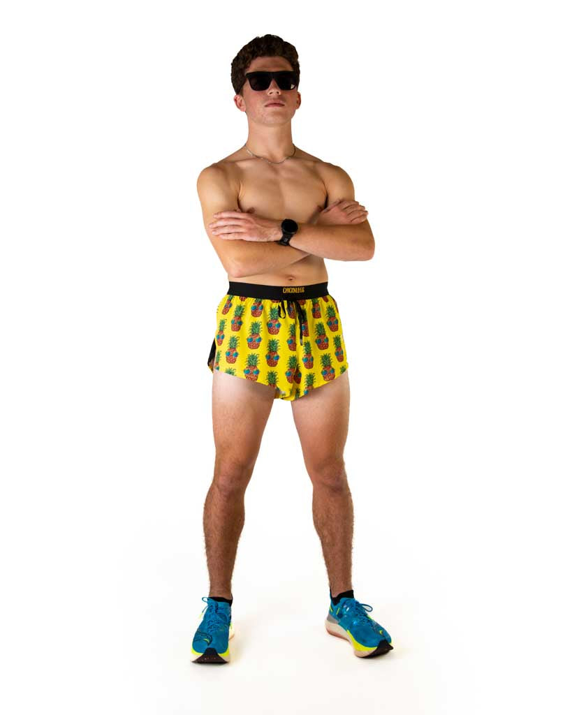 Male model wearing ChicknLegs yellow pineapple print 2-inch split running shorts