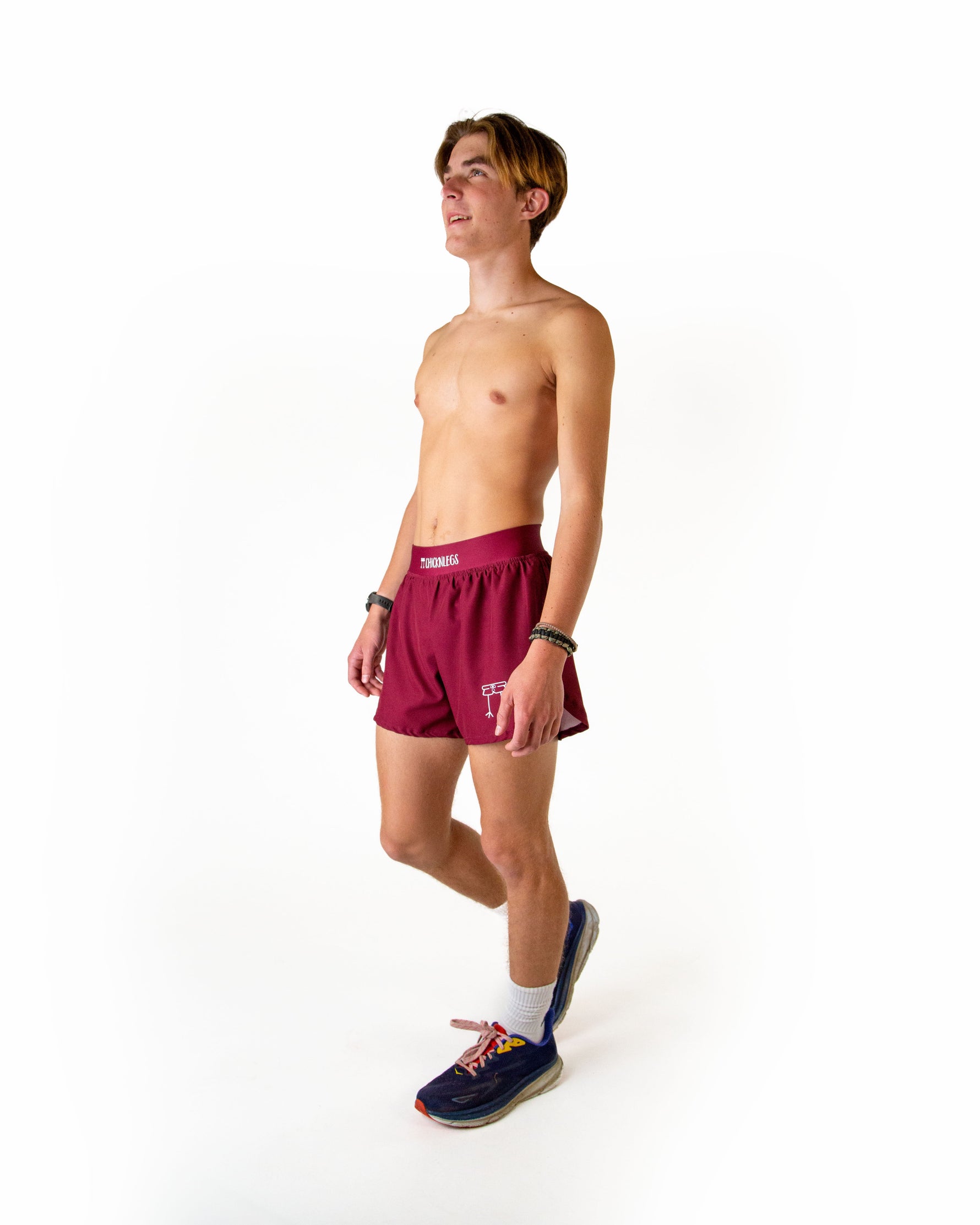Man wearing maroon ChicknLegs running shorts in professional studio photo