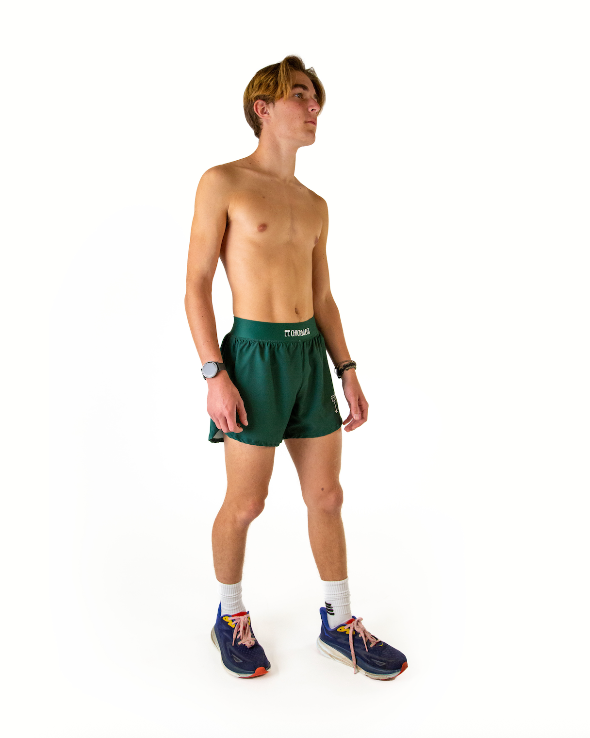 Shirtless male model wearing forest green athletic running shorts with half split design