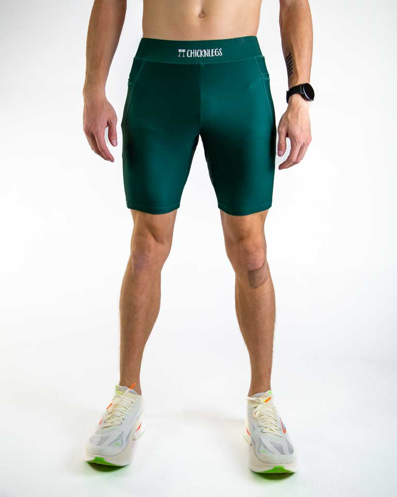 Man wearing ChicknLegs forest green compression shorts in studio setting