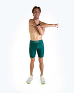 Man wearing ChicknLegs forest green compression shorts in studio photo
