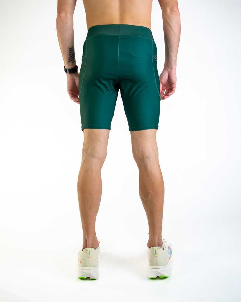 Man wearing forest green compression shorts, back view in studio setting