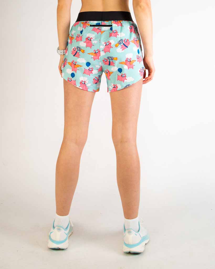 Woman wearing ChicknLegs Piggies 4-inch split shorts with pink pig pattern on mint background