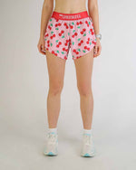 ChicknLegs 4-inch split running shorts in cherry print pattern on female model