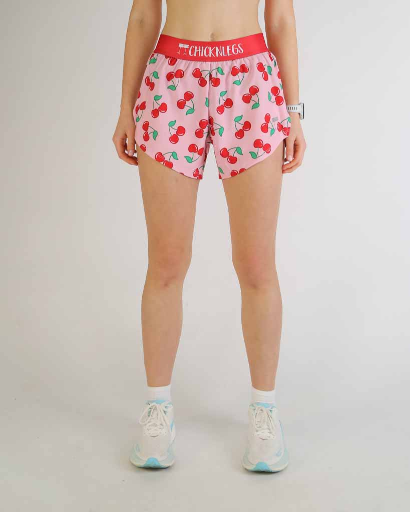 ChicknLegs 4-inch split running shorts in cherry print pattern on female model