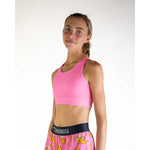 Woman wearing pink ChicknLegs sports bra and matching shorts with banana pattern