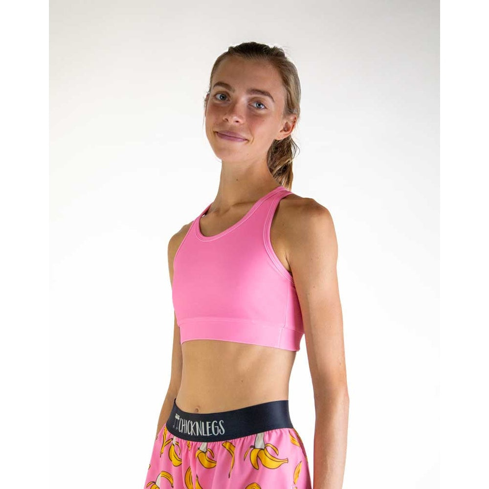 Woman wearing pink ChicknLegs sports bra and matching shorts with banana pattern