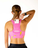 Woman wearing pink ChicknLegs sports bra with yellow lightning bolts, back view