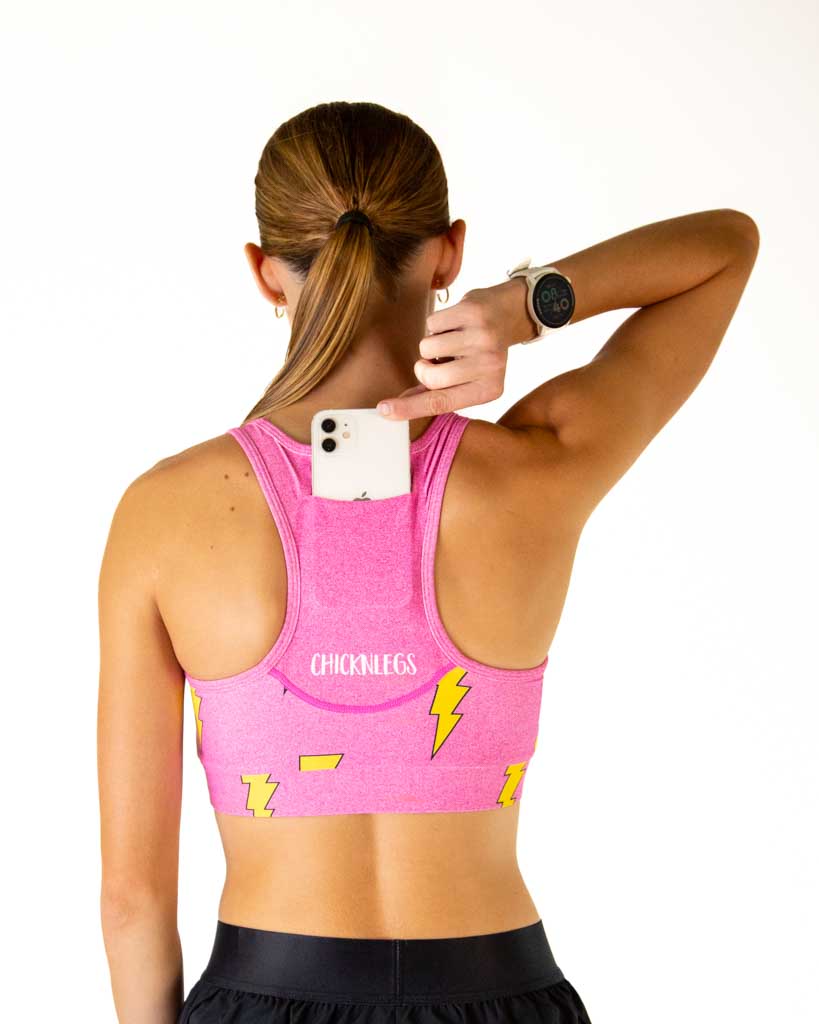Woman wearing pink ChicknLegs sports bra with yellow lightning bolts, back view