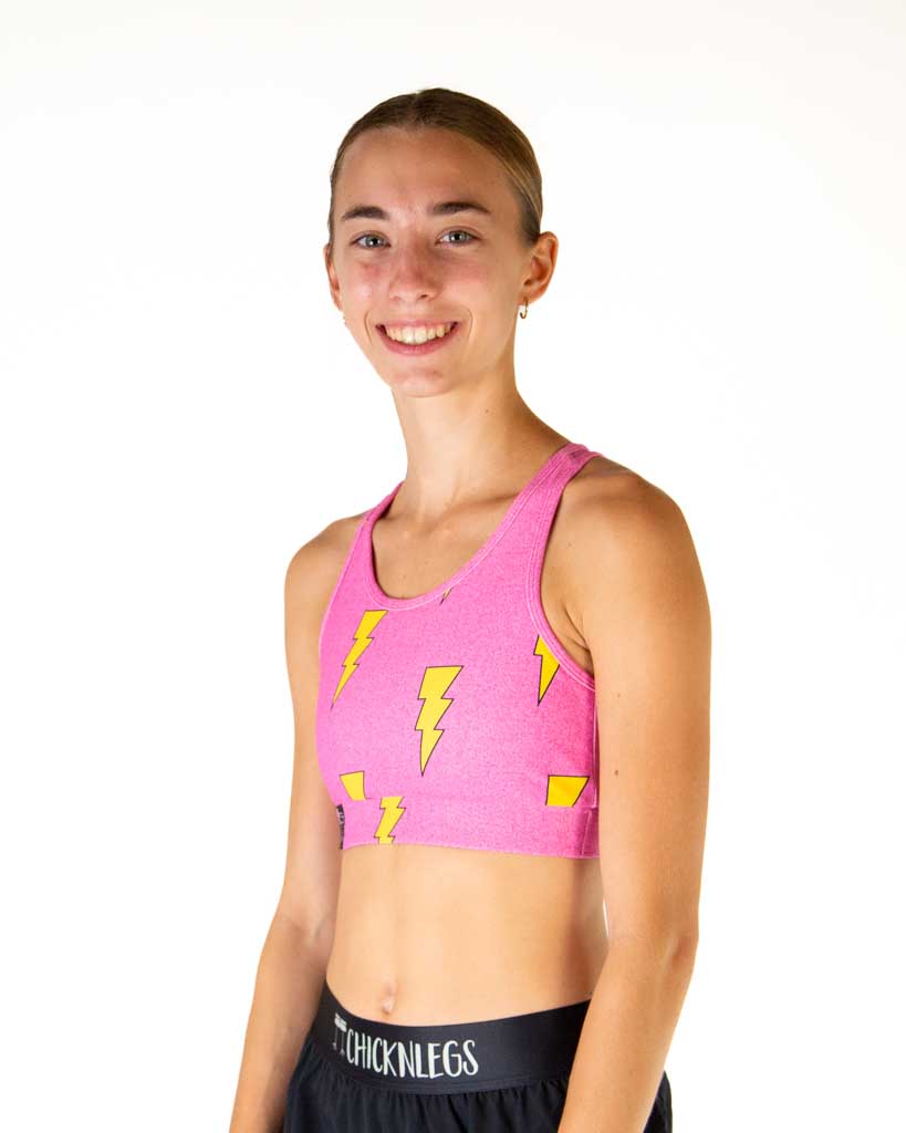 Woman wearing pink sports bra with yellow lightning bolt pattern