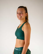 Woman wearing ChicknLegs forest green sports bra and matching shorts