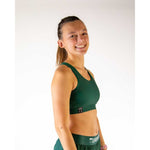 Woman wearing forest green ChicknLegs OG sports bra with matching bottoms