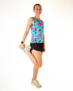 Woman wearing turquoise athletic tank top with pink flamingo and pineapple print