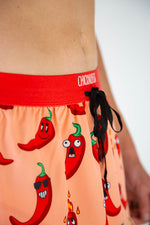 ChicknLegs men's running shorts with cartoon chili pepper print on peach background