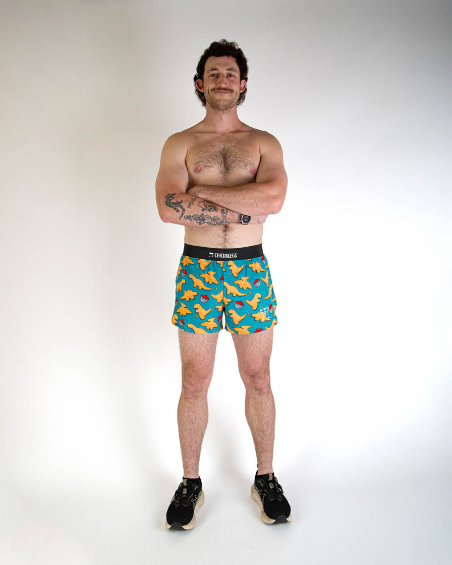 Man wearing ChicknLegs blue shorts with orange chicken nugget print pattern