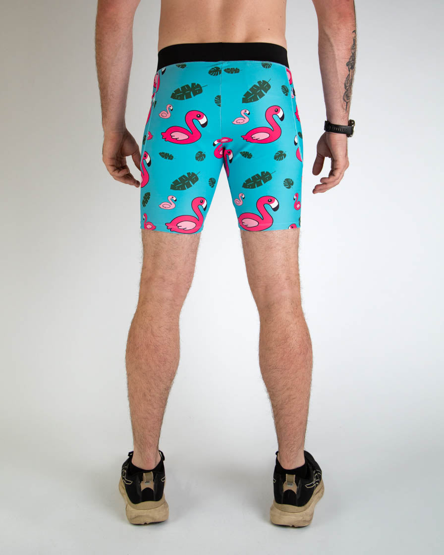 Man wearing turquoise blue half tights with pink flamingo and tropical leaf pattern