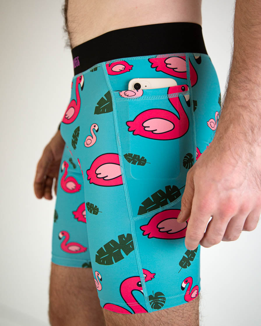 Men's turquoise compression shorts with pink flamingo and tropical leaf pattern