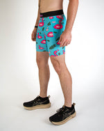 Man wearing turquoise blue half tights with pink flamingo pattern and black waistband
