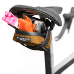ALMSTHRE saddle bag in black and orange attached to bike seat with tools visible