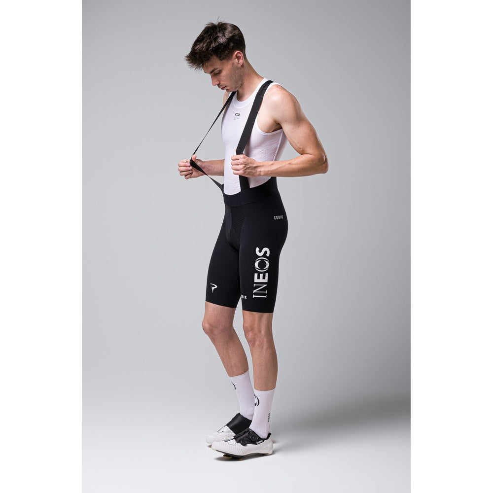 Male cyclist wearing black Gobik Lancer bib shorts with white INEOS Grenadiers team branding