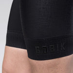 Close-up of black Gobik cycling bib shorts showing textured fabric detail and logo