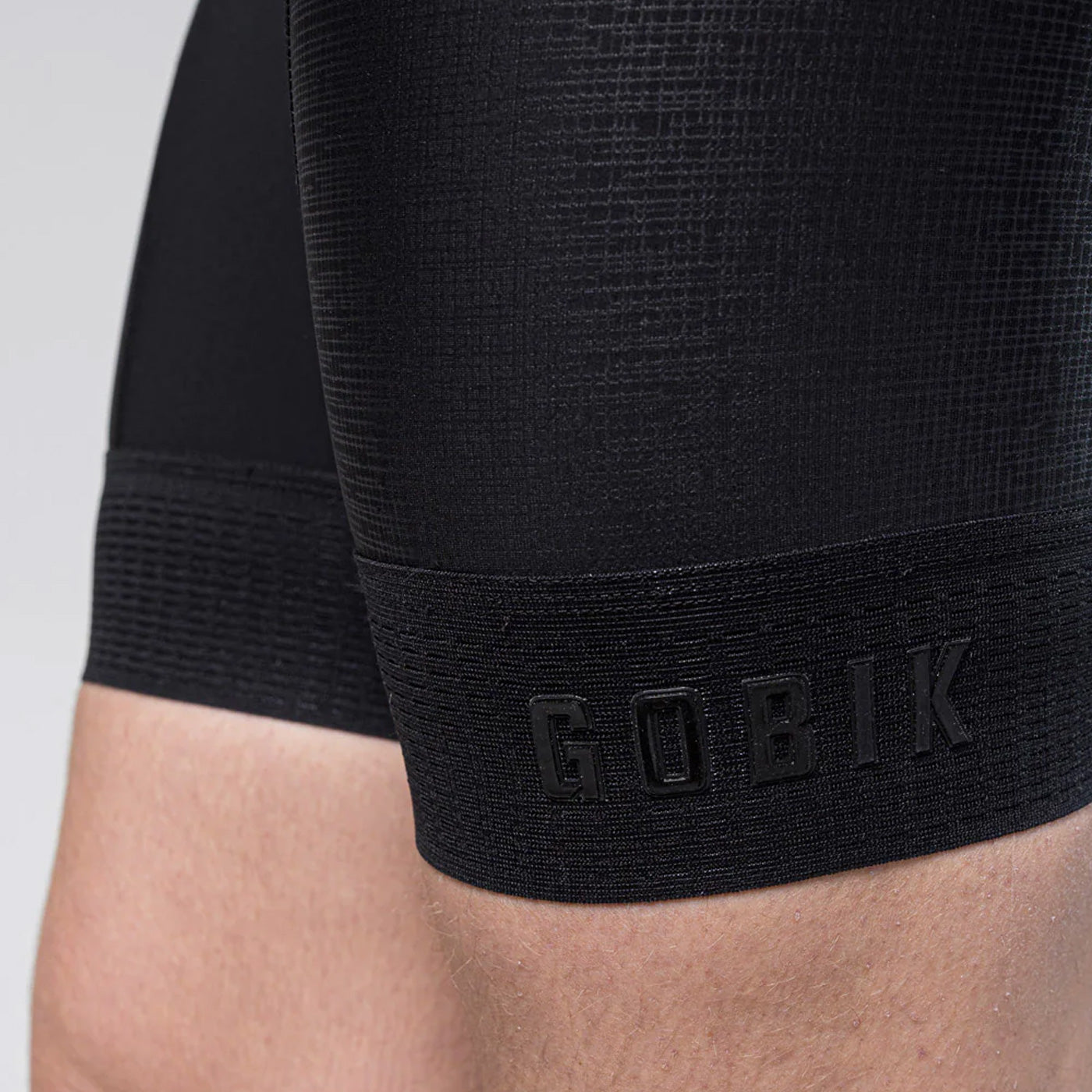Close-up of black Gobik cycling bib shorts showing textured fabric detail and logo
