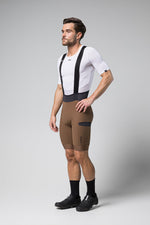 Man wearing Gobik Grit bib shorts in toffee brown color with white jersey