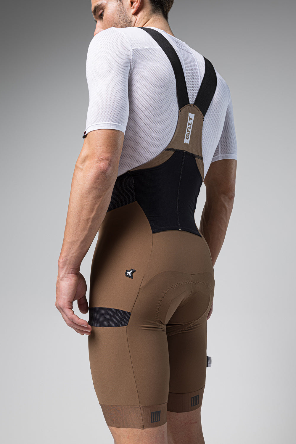 Man wearing Gobik Grit bib shorts in toffee brown color with suspenders