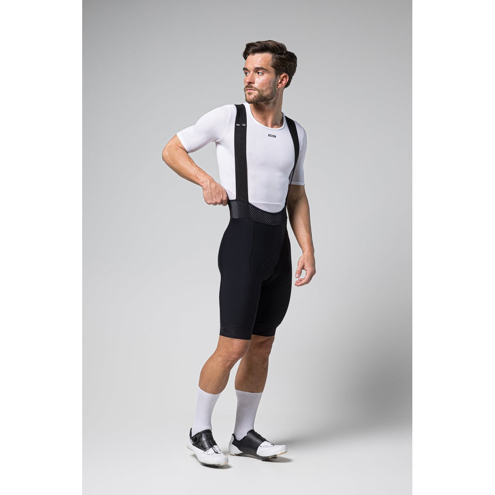 Male cyclist wearing black Gobik Limited 6.0 bib shorts with white jersey