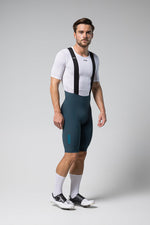 Male cyclist wearing Gobik Matt 2.0 bib shorts in corsair color with white base layer