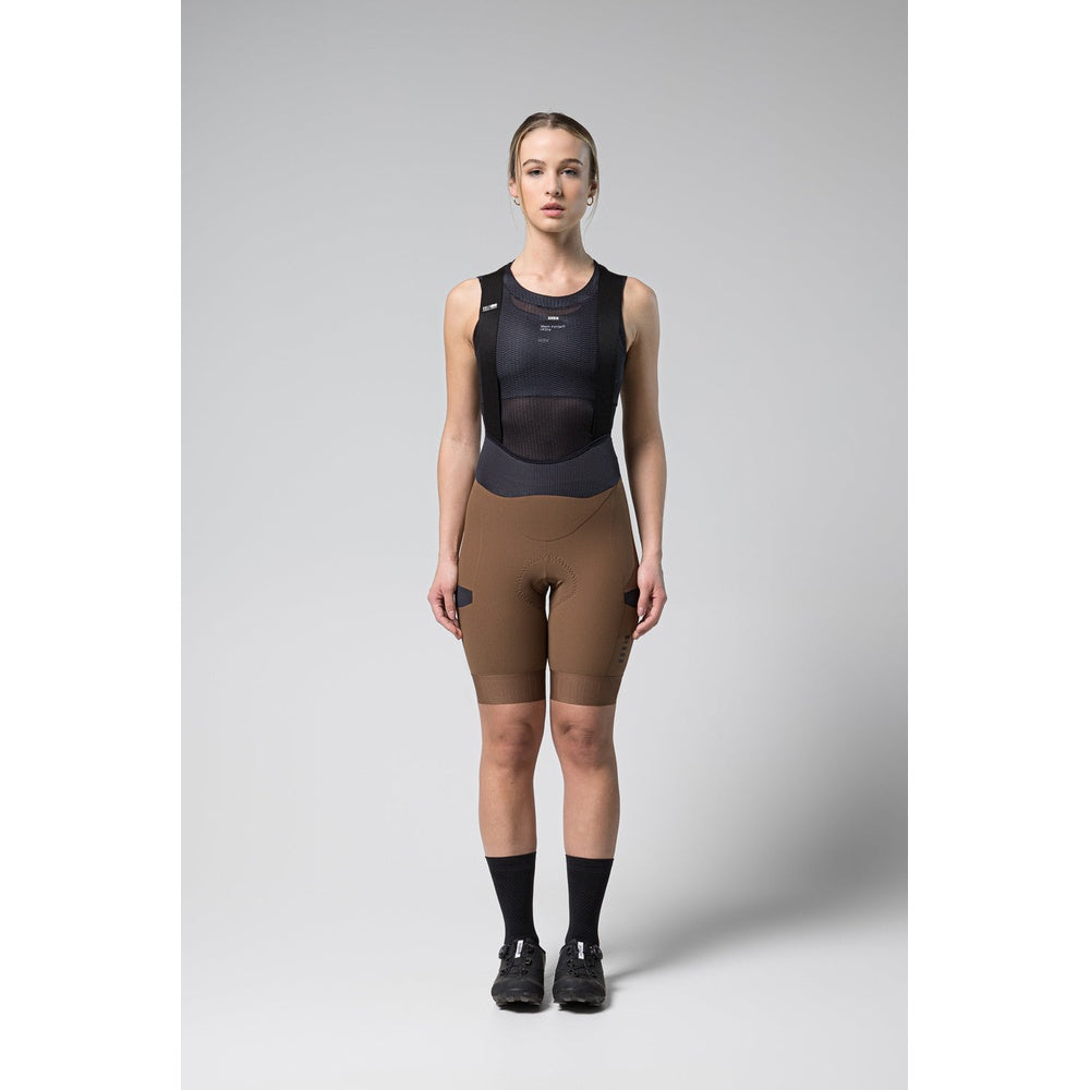 Woman wearing Gobik Grit bib shorts in toffee brown with black base layer