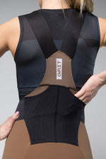 Gobik Grit women's bib shorts in toffee brown and black worn by model