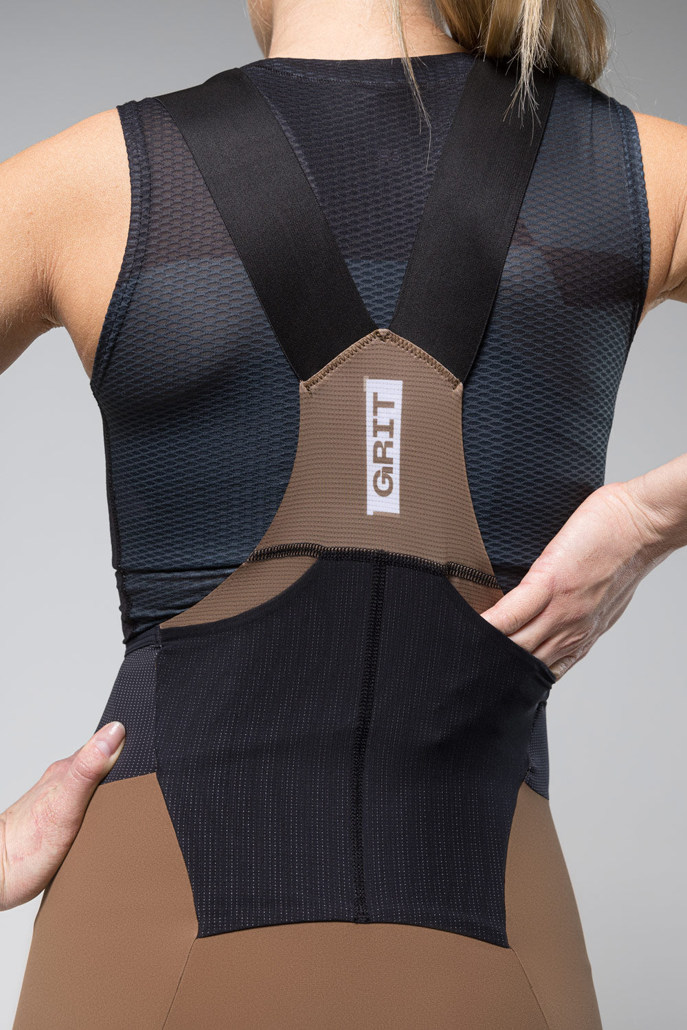 Gobik Grit women's bib shorts in toffee brown and black worn by model