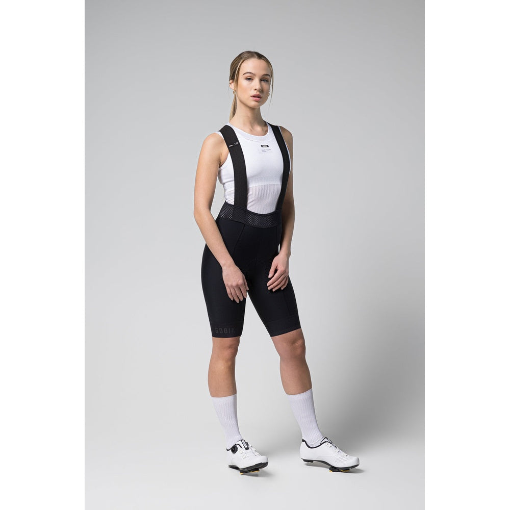 Woman wearing black Gobik Limited 6.0 bib shorts with white tank top
