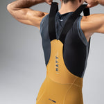 Gobik Matt Compact Men's Bibshort in Turmeric showing back view with suspenders