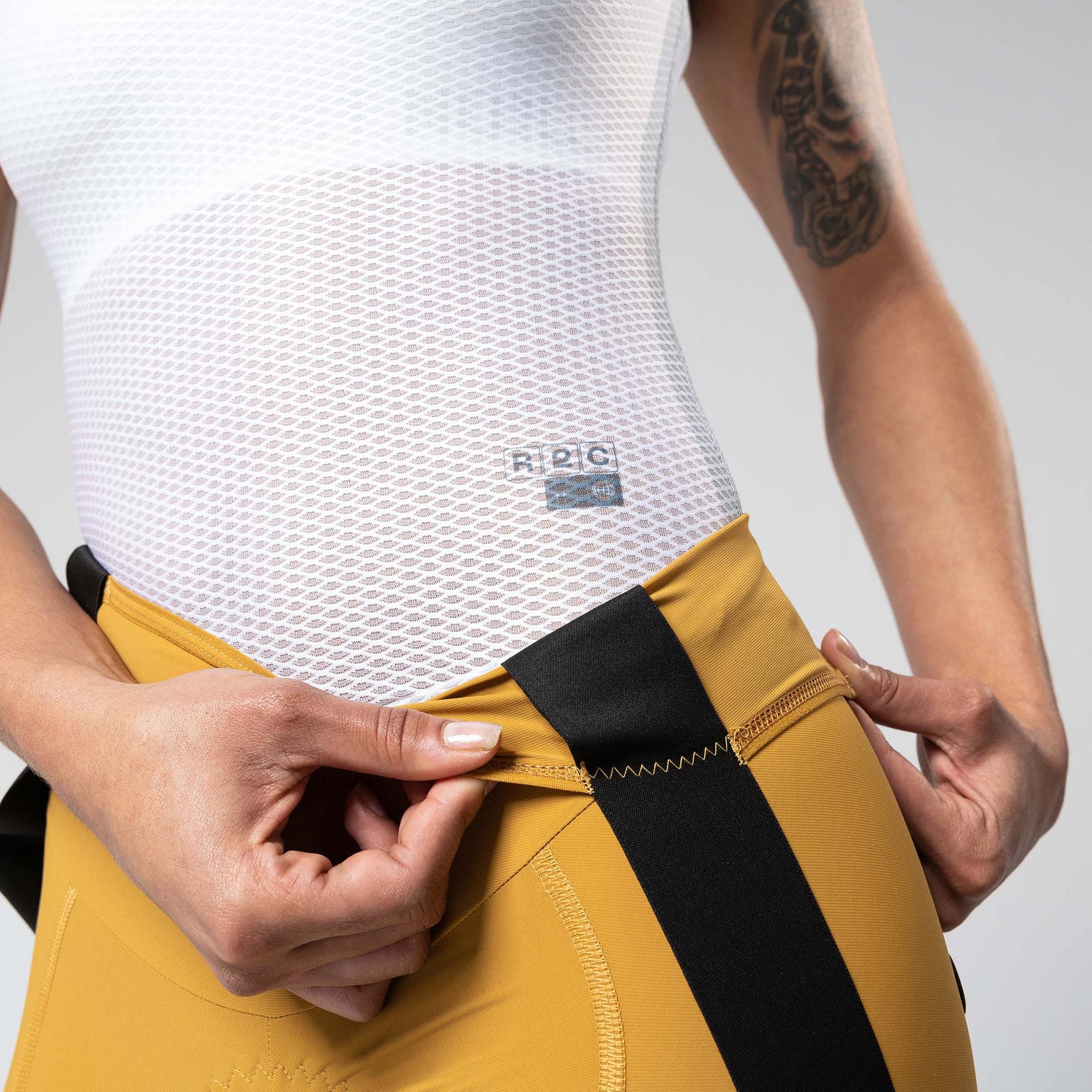 Gobik Matt Women's Bib Shorts in Turmeric showing waistband detail and fabric construction