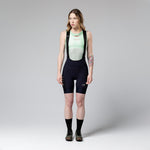 Woman wearing Gobik Matt bib shorts in ultrablue navy color with professional studio lighting